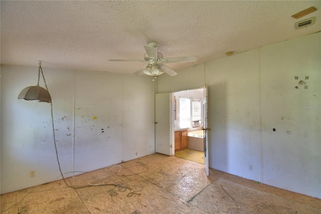 1294 1/2 38th St NW, Winter Haven, FL 33881 - unfurnished bedroom with a textured ceiling, ensuite bathroom, and ceiling fan