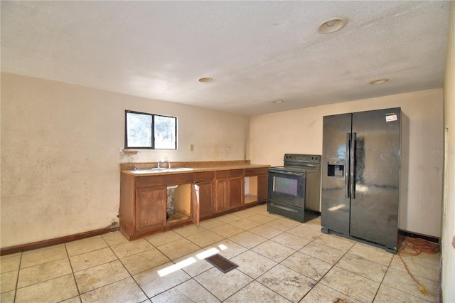 1294 1/2 38th St NW, Winter Haven, FL 33881 - kitchen featuring black appliances, brown cabinetry, light tile patterned flooring, a sink, and light countertops