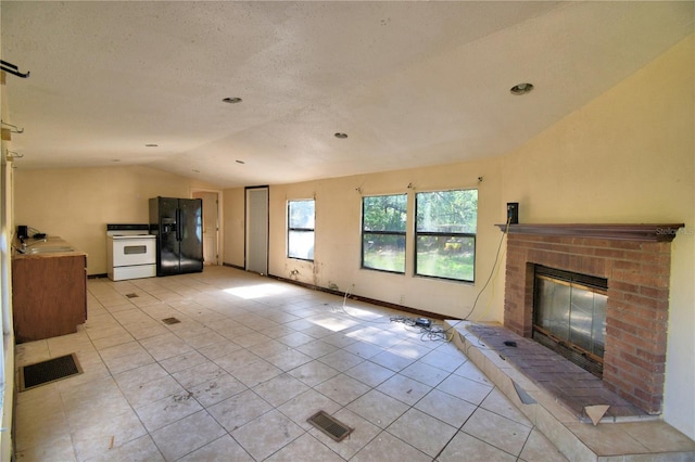 1294 1/2 38th St NW, Winter Haven, FL 33881 - unfurnished living room featuring lofted ceiling, light tile patterned floors, and a brick fireplace