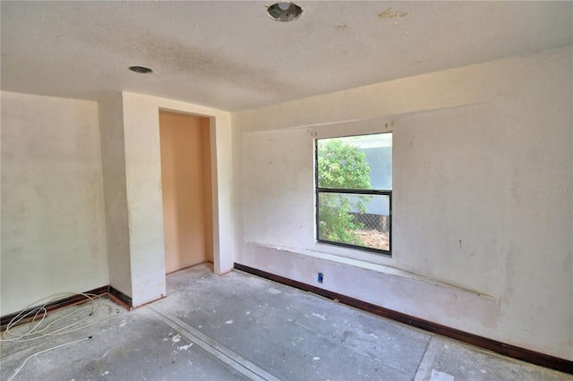 1294 1/2 38th St NW, Winter Haven, FL 33881 - unfurnished room with a textured ceiling, unfinished concrete floors, and baseboards