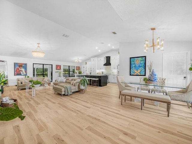 living area with vaulted ceiling, a chandelier, light wood finished floors, and recessed lighting