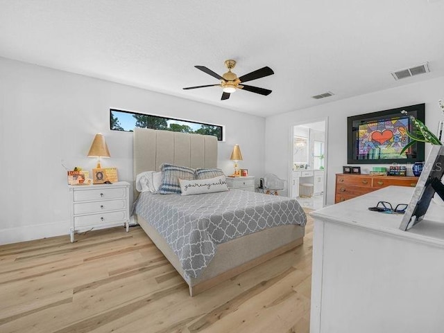 bedroom featuring light wood-style floors, ensuite bath, a ceiling fan, and baseboards