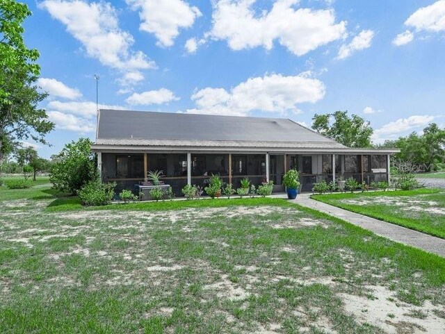 view of front facade with a sunroom and a front lawn