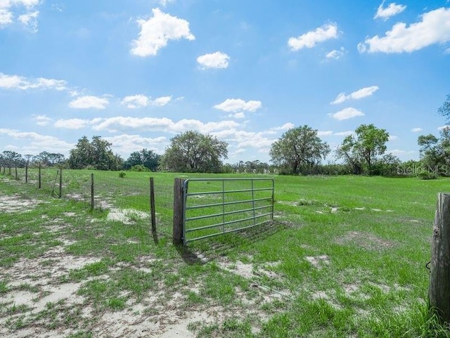 gate featuring a rural view and fence