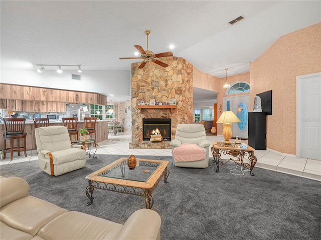 409 N 6th St, Lake Hamilton, FL 33851 - tiled living room featuring ceiling fan, a fireplace, carpet, and high vaulted ceiling