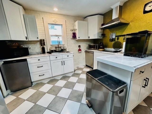 kitchen with wall chimney exhaust hood, black appliances, light countertops, and white cabinetry