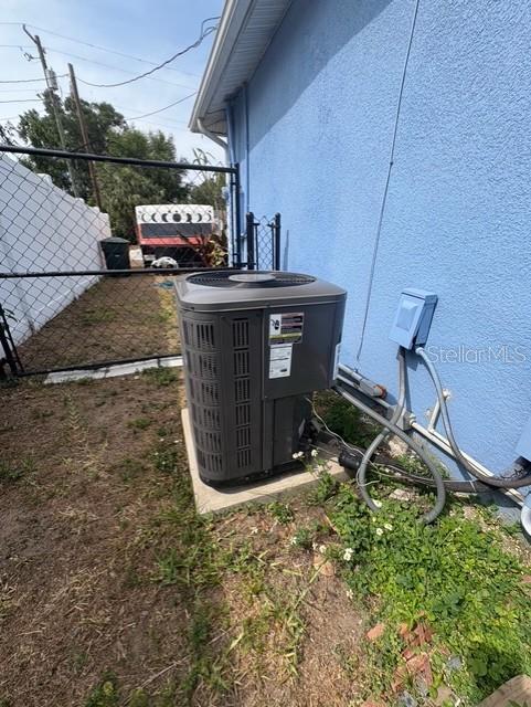 exterior view of central AC unit and stucco siding