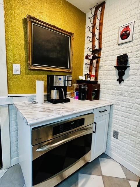 bar with stainless steel oven and a textured wall