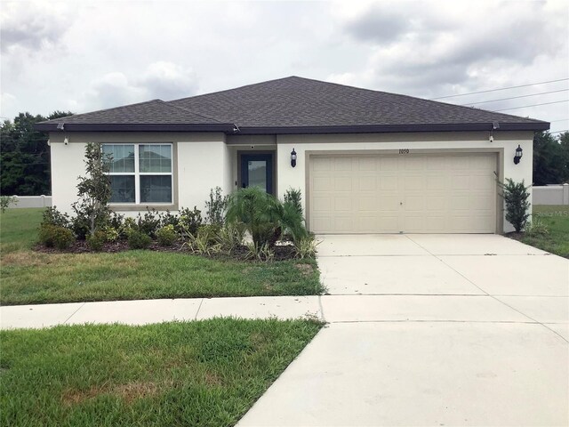 1050 Michelangelo Ln, Winter Haven, FL 33884 - single story home featuring stucco siding, a shingled roof, driveway, an attached garage, and a front lawn