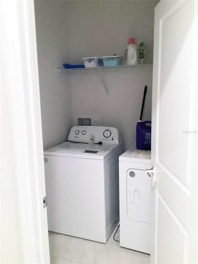 1050 Michelangelo Ln, Winter Haven, FL 33884 - laundry area with washing machine and dryer and light tile patterned floors