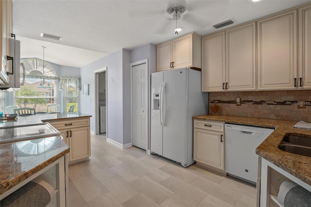 4005 Carter Creek Dr, Avon Park, FL 33825 - kitchen featuring white appliances, cream cabinets, backsplash, stone counters, and vaulted ceiling