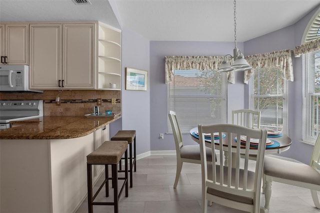 4005 Carter Creek Dr, Avon Park, FL 33825 - dining space featuring baseboards, a chandelier, and lofted ceiling