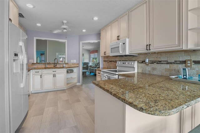 4005 Carter Creek Dr, Avon Park, FL 33825 - kitchen with white appliances, open shelves, decorative backsplash, stone countertops, and a peninsula