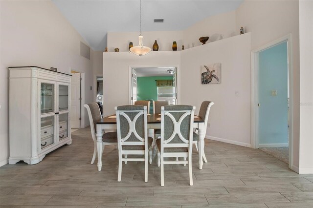 4005 Carter Creek Dr, Avon Park, FL 33825 - dining room with high vaulted ceiling, light wood-style floors, ceiling fan, and baseboards