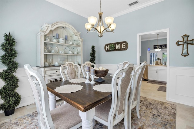 109 Lake Mariam Way, Winter Haven, FL 33884 - dining space with crown molding, a chandelier, wainscoting, and a decorative wall