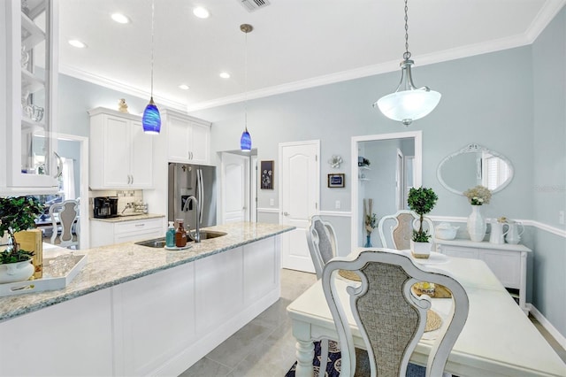 109 Lake Mariam Way, Winter Haven, FL 33884 - kitchen featuring stainless steel refrigerator with ice dispenser, crown molding, white cabinetry, glass insert cabinets, and pendant lighting