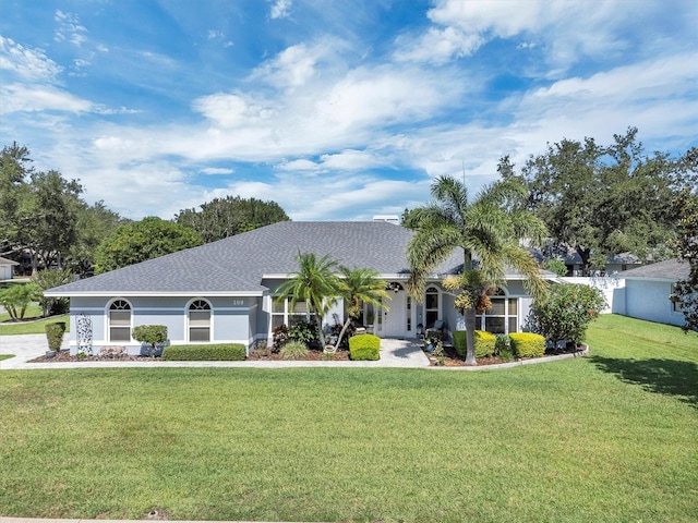 109 Lake Mariam Way, Winter Haven, FL 33884 - ranch-style house with a front yard, a shingled roof, and stucco siding