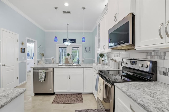 109 Lake Mariam Way, Winter Haven, FL 33884 - kitchen featuring stainless steel appliances, a sink, a peninsula, white cabinets, and ornamental molding