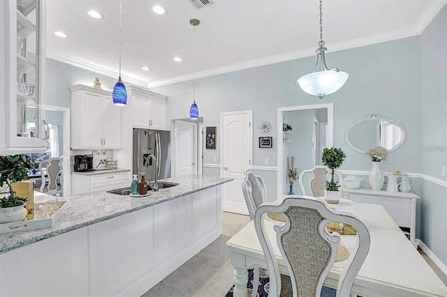 109 Lake Mariam Way, Winter Haven, FL 33884 - kitchen with stainless steel refrigerator with ice dispenser, a sink, crown molding, white cabinets, and glass insert cabinets