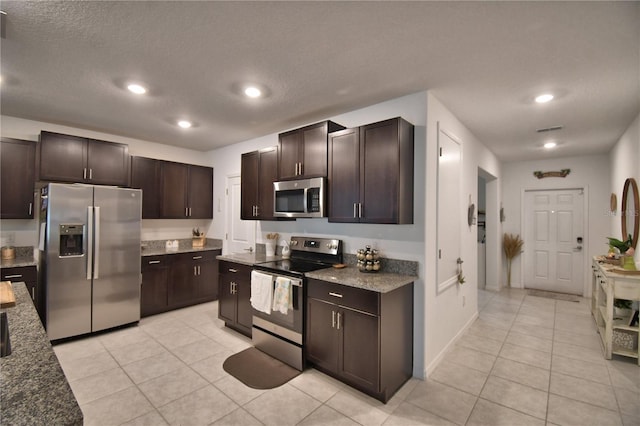 4400 Trotters Way, Lakeland, FL 33801 - kitchen featuring stainless steel appliances, light tile patterned flooring, dark brown cabinets, a textured ceiling, and recessed lighting