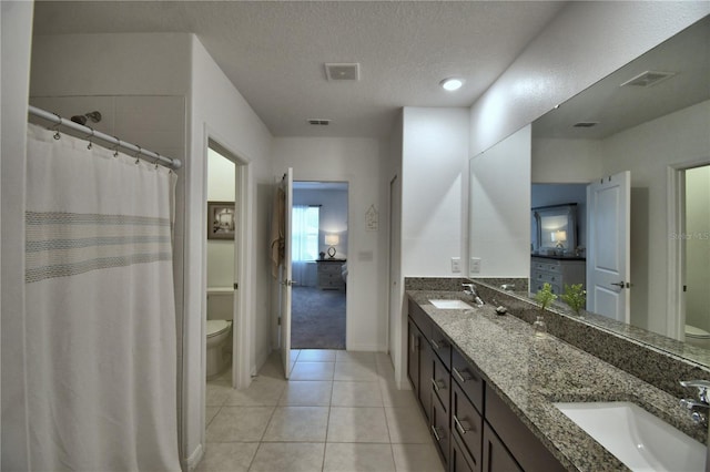 4400 Trotters Way, Lakeland, FL 33801 - full bathroom with toilet, tile patterned flooring, double vanity, a textured ceiling, and baseboards