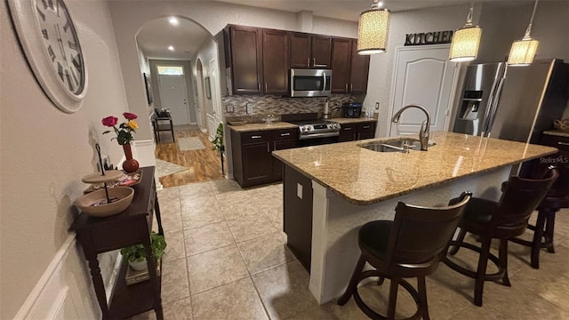 3828 Eloise Estates Ct, Winter Haven, FL 33881 - kitchen with appliances with stainless steel finishes, a sink, backsplash, and a breakfast bar