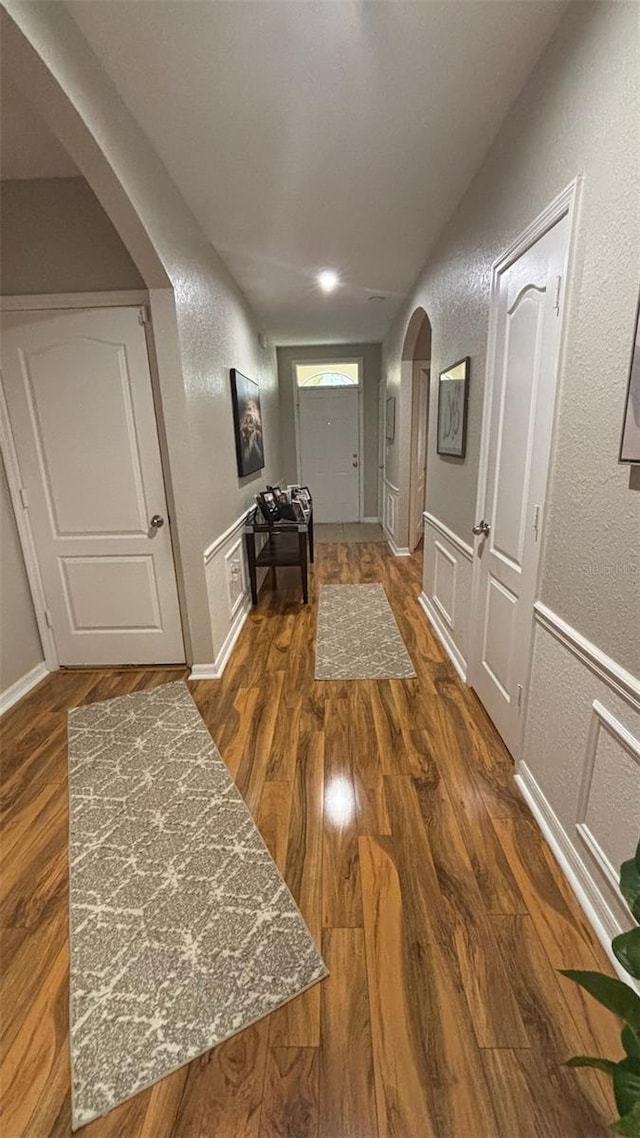 3828 Eloise Estates Ct, Winter Haven, FL 33881 - hall with arched walkways, a textured wall, and wood finished floors