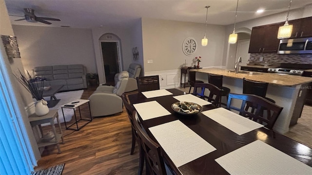 3828 Eloise Estates Ct, Winter Haven, FL 33881 - dining area featuring ceiling fan, dark wood-style flooring, and a wainscoted wall