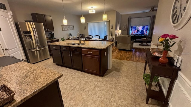 3828 Eloise Estates Ct, Winter Haven, FL 33881 - kitchen featuring stainless steel fridge with ice dispenser, a sink, dark brown cabinetry, light tile patterned floors, and light stone counters