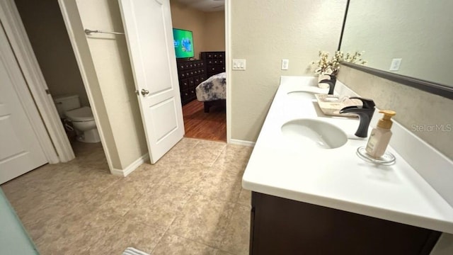 3828 Eloise Estates Ct, Winter Haven, FL 33881 - bathroom with toilet, double vanity, tile patterned flooring, ensuite bath, and baseboards