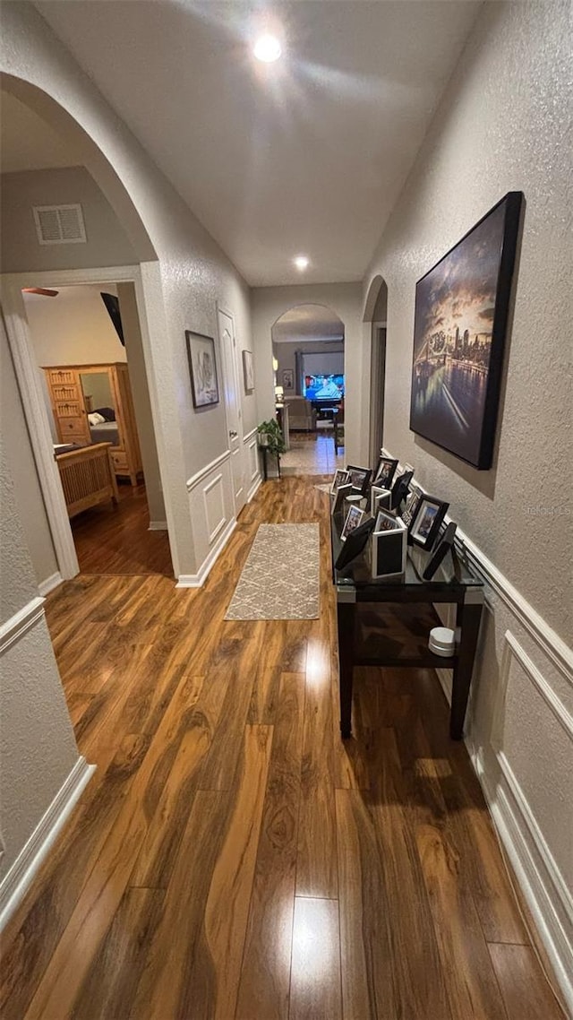 3828 Eloise Estates Ct, Winter Haven, FL 33881 - hall featuring arched walkways, a textured wall, wood finished floors, recessed lighting, and a wainscoted wall