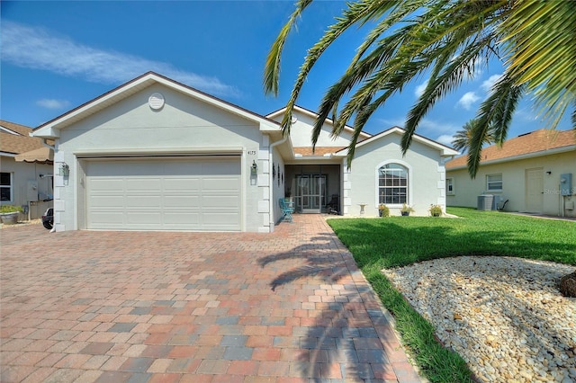 4175 Muirfield Loop, Lake Wales, FL 33859 - ranch-style house featuring stucco siding, decorative driveway, a front lawn, an attached garage, and cooling unit