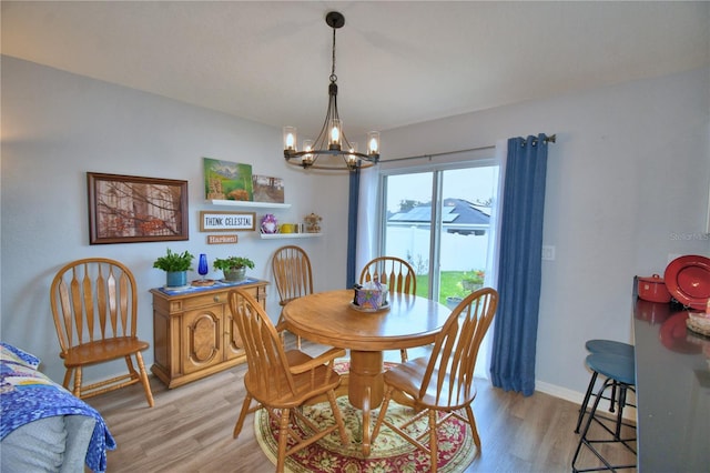 879 Orleans Dr, Eagle Lake, FL 33839 - dining space featuring a chandelier, light wood-type flooring, and baseboards