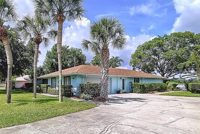 255 Lake Link Rd, Winter Haven, FL 33884 - single story home with an attached garage, a front yard, concrete driveway, and stucco siding