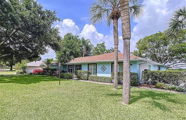 255 Lake Link Rd, Winter Haven, FL 33884 - ranch-style house featuring a front lawn, stucco siding, and a garage