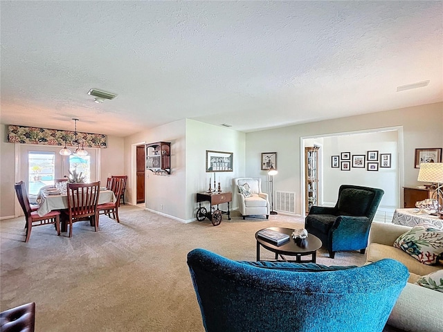 255 Lake Link Rd, Winter Haven, FL 33884 - living room featuring a textured ceiling, light carpet, baseboards, and a chandelier