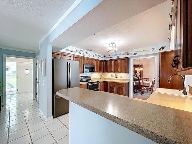 255 Lake Link Rd, Winter Haven, FL 33884 - kitchen with appliances with stainless steel finishes, a textured ceiling, a sink, a peninsula, and light tile patterned floors