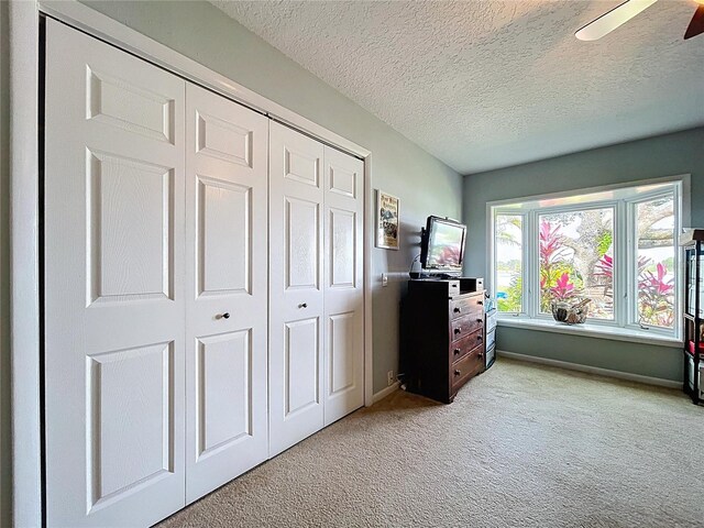 255 Lake Link Rd, Winter Haven, FL 33884 - bedroom with light carpet, a textured ceiling, a closet, baseboards, and a ceiling fan