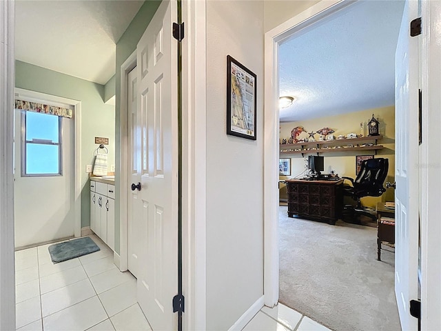 255 Lake Link Rd, Winter Haven, FL 33884 - hallway featuring an office area, light tile patterned flooring, light colored carpet, baseboards, and a textured ceiling