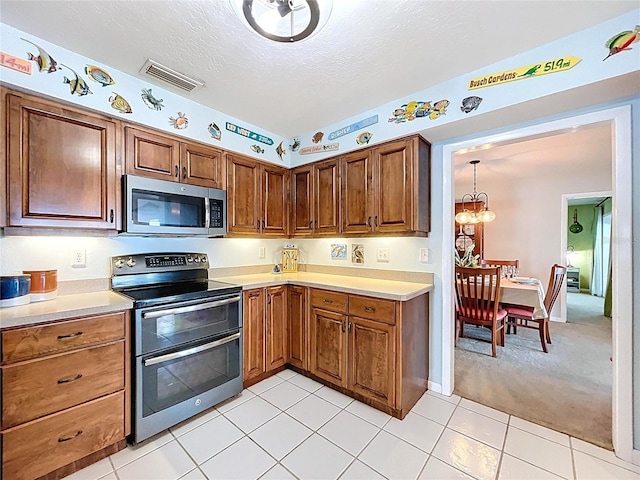255 Lake Link Rd, Winter Haven, FL 33884 - kitchen with stainless steel appliances, light countertops, a chandelier, brown cabinets, and a textured ceiling