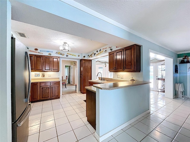 255 Lake Link Rd, Winter Haven, FL 33884 - kitchen with freestanding refrigerator, a textured ceiling, plenty of natural light, and light tile patterned floors