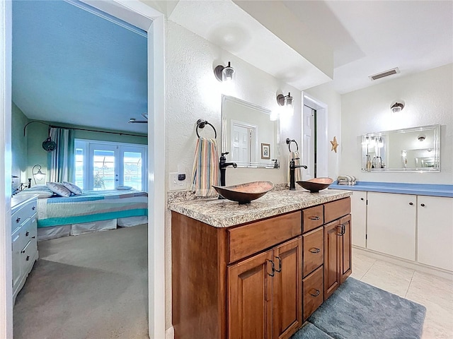 255 Lake Link Rd, Winter Haven, FL 33884 - bathroom featuring ensuite bathroom, vanity, a textured wall, and tile patterned floors