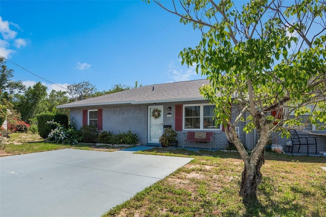 1408 Thousand Roses Dr S, Lake Wales, FL 33853 - ranch-style home with brick siding, a front yard, and roof with shingles