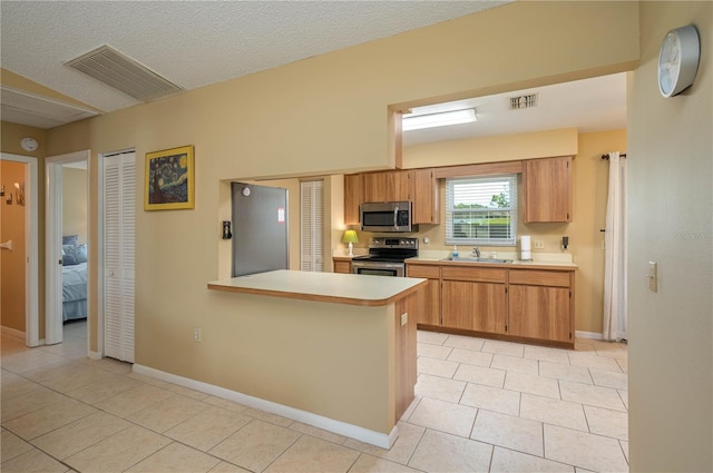 3245 Prairie Dunes Cir E, Lakeland, FL 33810 - kitchen featuring stainless steel appliances, a sink, light countertops, light tile patterned floors, and a peninsula