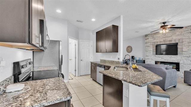 428 Aragosa Dr, Davenport, FL 33837 - kitchen featuring a sink, stainless steel appliances, a peninsula, light tile patterned flooring, and recessed lighting