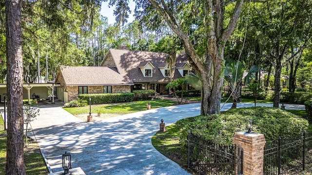 418 N Rd, Lakeland, FL 33809 - view of front of house featuring concrete driveway, a chimney, and roof with shingles