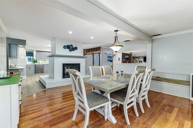 418 N Rd, Lakeland, FL 33809 - dining space with ornamental molding, light wood-type flooring, a brick fireplace, and wainscoting