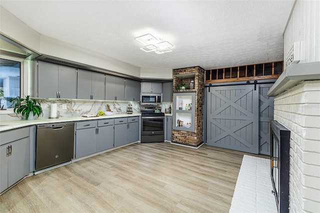 418 N Rd, Lakeland, FL 33809 - kitchen featuring stainless steel appliances, gray cabinetry, a textured ceiling, light wood-style floors, and light countertops