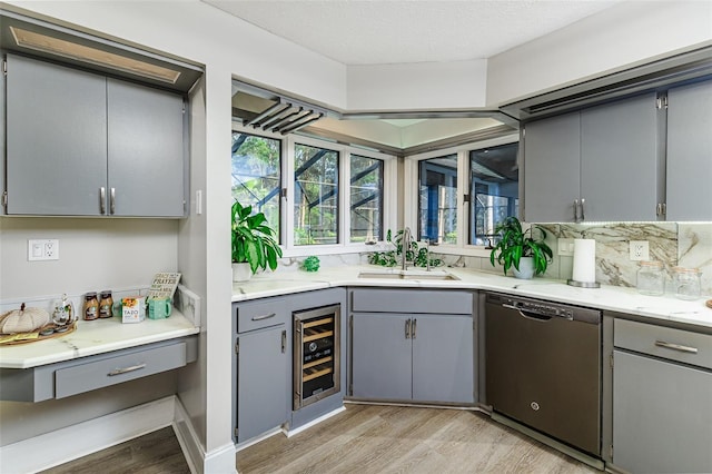 418 N Rd, Lakeland, FL 33809 - kitchen with dishwasher, gray cabinets, a sink, beverage cooler, and light wood-type flooring