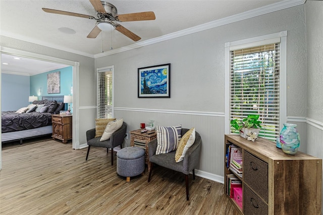 418 N Rd, Lakeland, FL 33809 - living area with light wood-style floors, ornamental molding, a wainscoted wall, and a ceiling fan